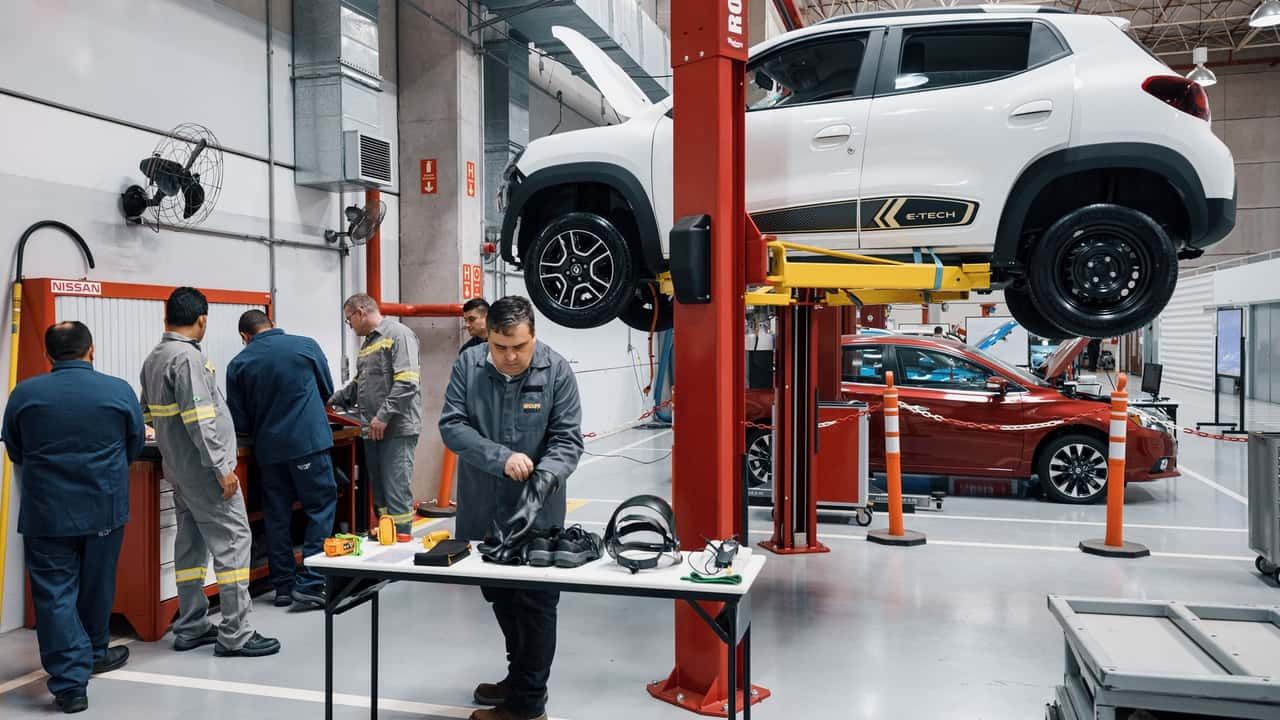 Técnico realizando manutenção em carro elétrico em oficina especializada Brasil 2026